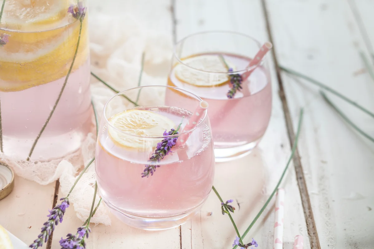 Lavender lemonade in glass with drinking straw