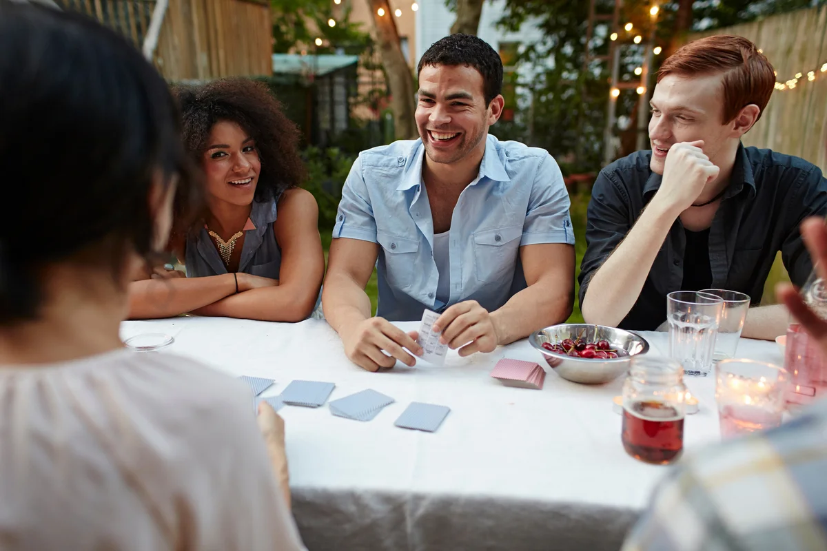 Friends playing cards and enjoying drinks