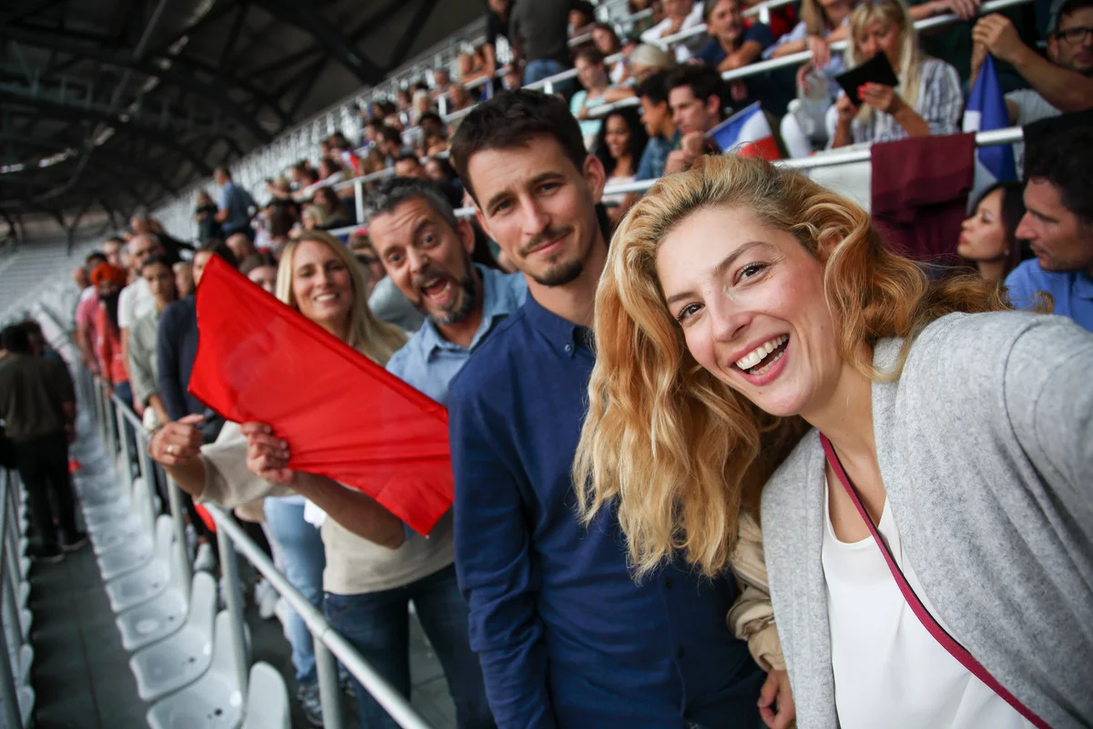 Couple and friends taking selfie at sporting event