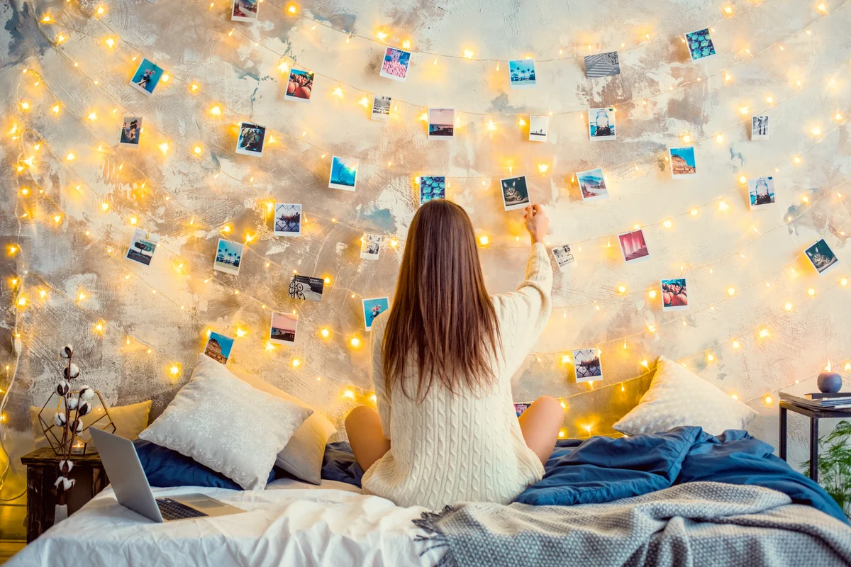 Young woman touching photo on decorated wall
