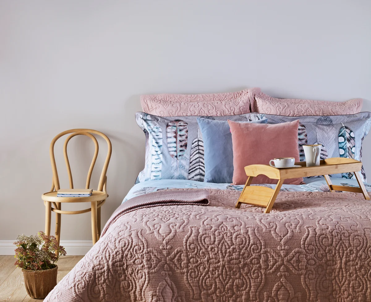bed with rose-colored quilt