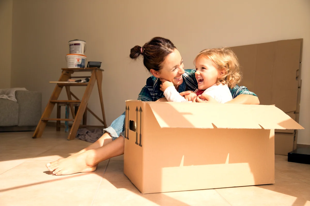 Woman and daughter sitting in moving boxes