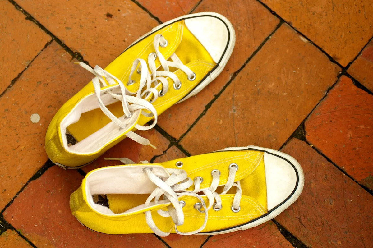 Yellow Chucks on a brick patio