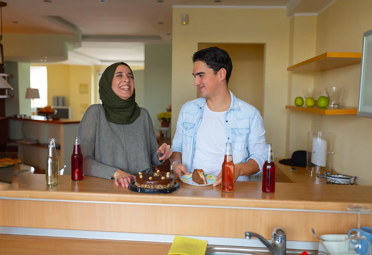 Young couple enjoying desserts and drinks in apartment
