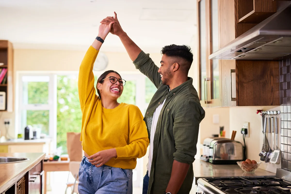 Beautiful young couple dancing in the kitchen