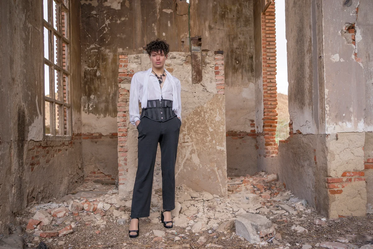 Androgynous person posing standing up in cool crumbling building