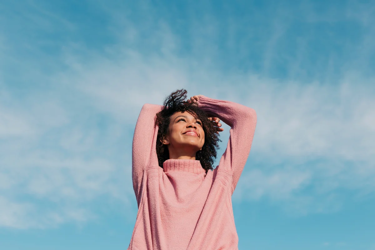 Girl smiling with a blue sky behind her
