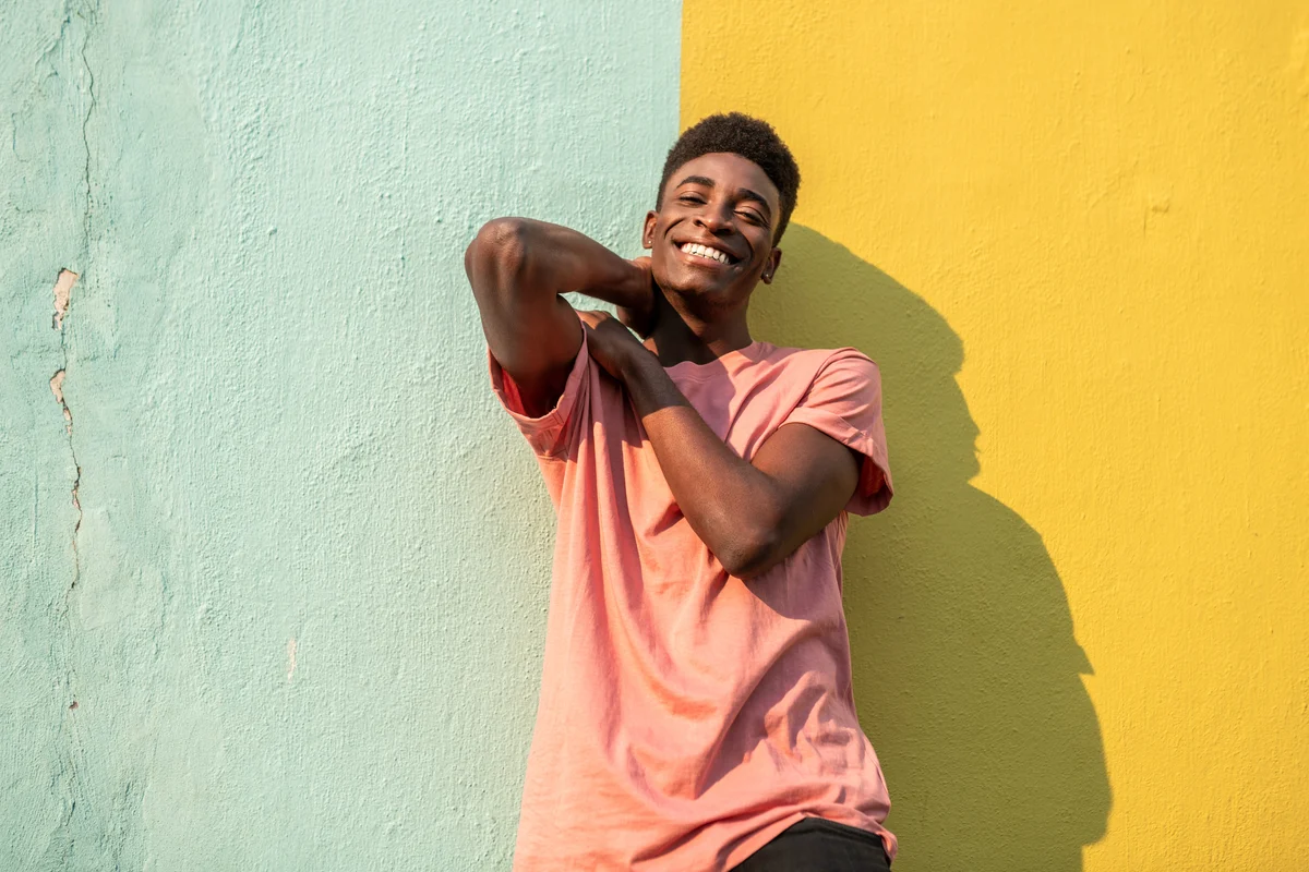 Boy with big smile in front of colorful wall