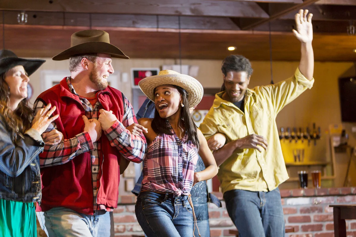 Multi-ethnic group of friends dancing in a bar