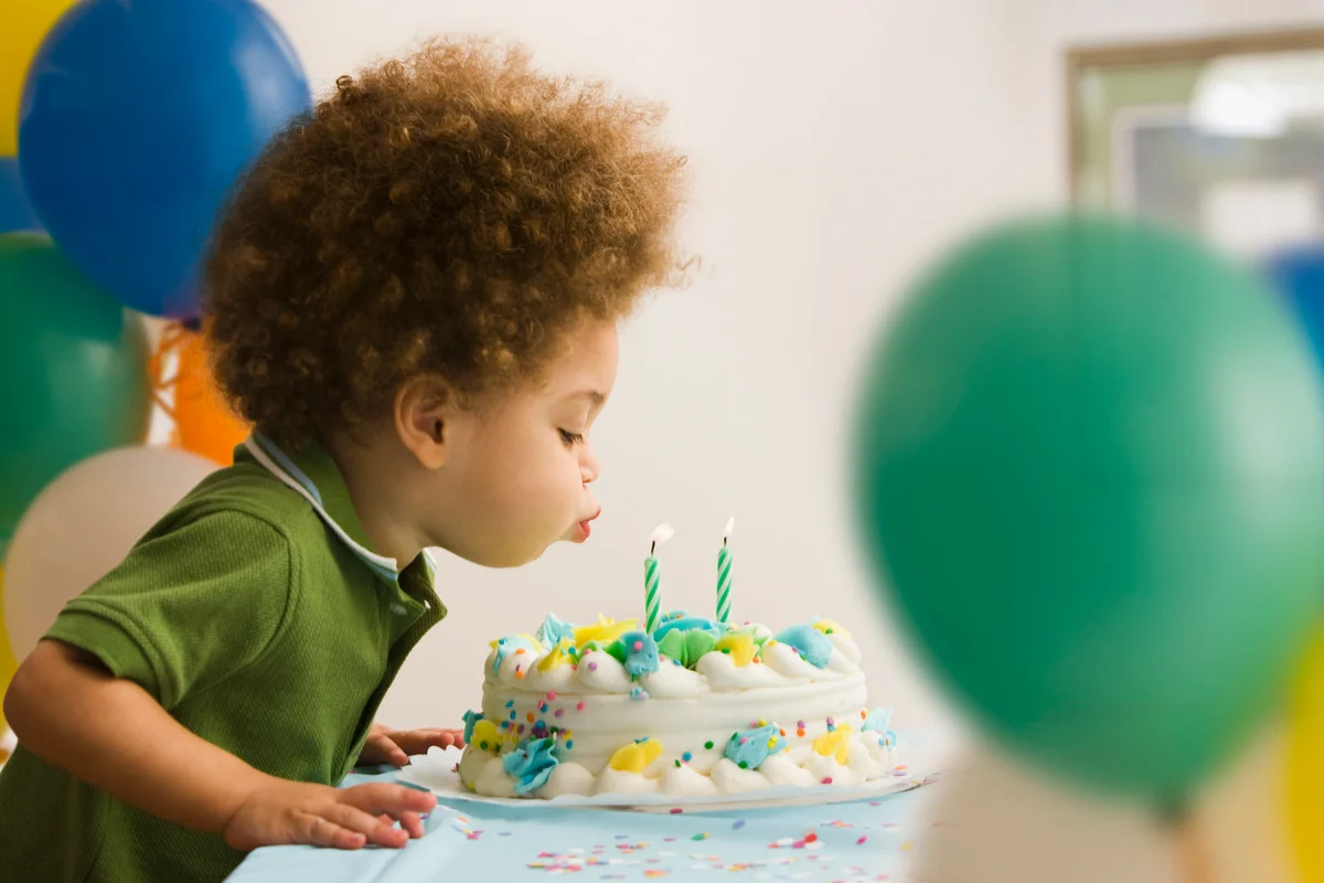 child blowing out birthday candles
