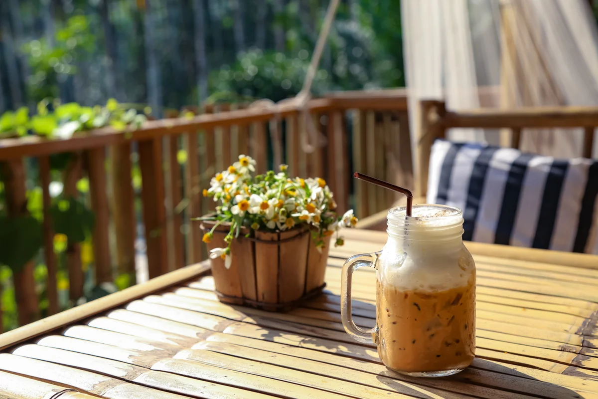 Close-Up Of Iced Coffee Served In Mason Jar On Table At Balcony