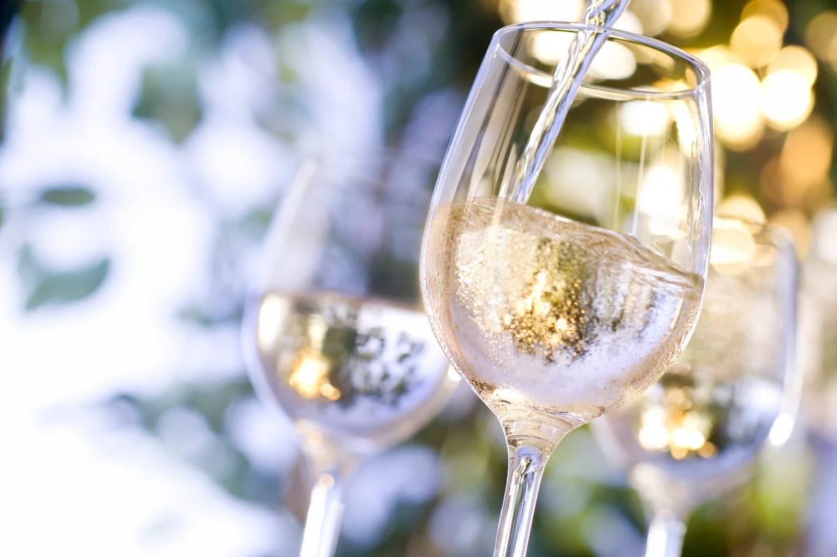 white wine being poured into a glass
