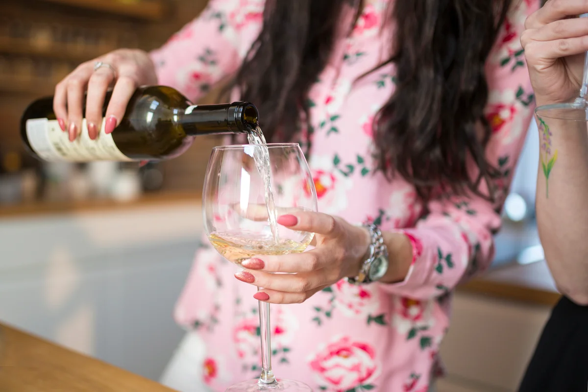 Close up of woman pouring white wine
