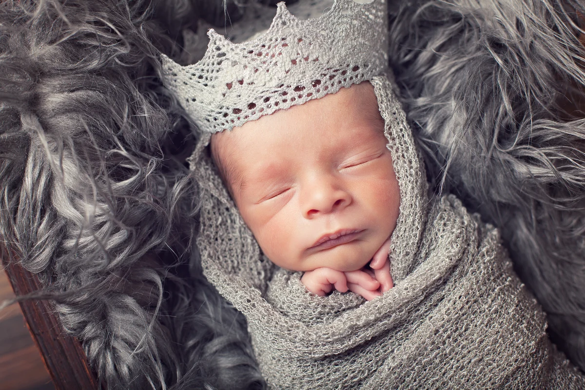 sleeping baby wearing a silver crown