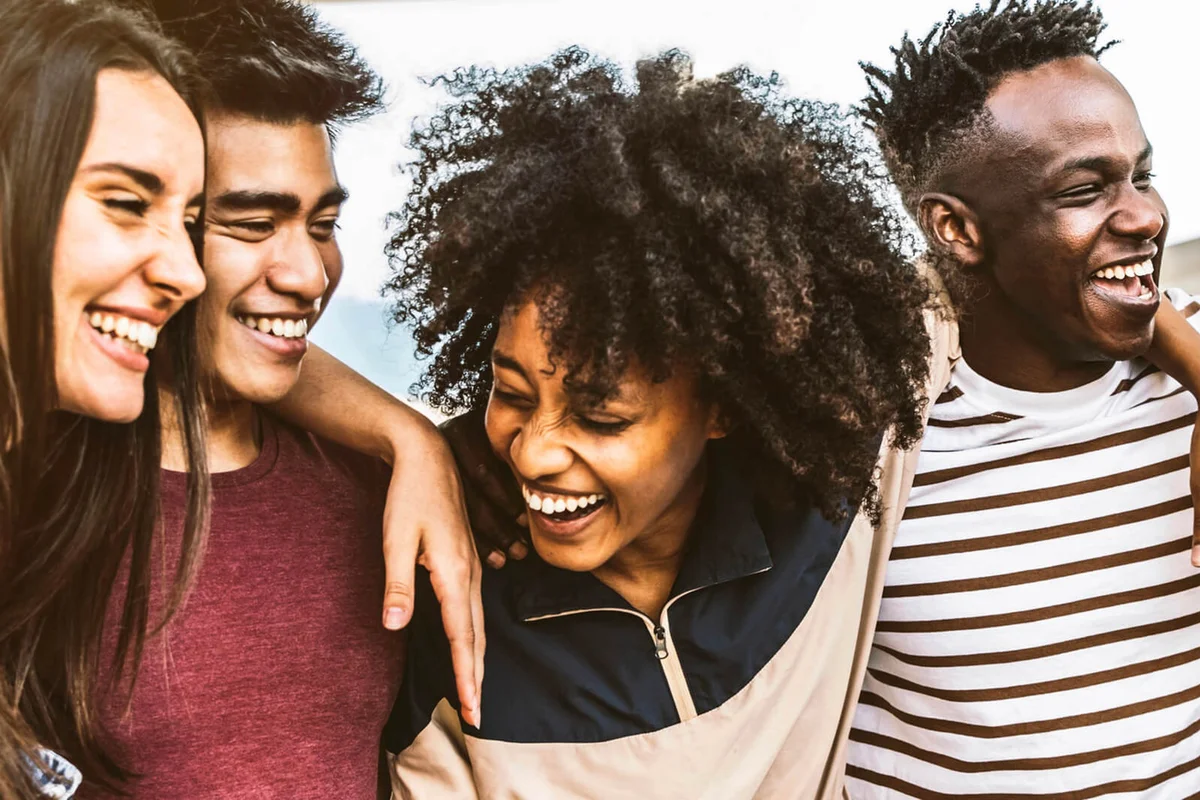 Cheerful young people walking outside talking and having fun