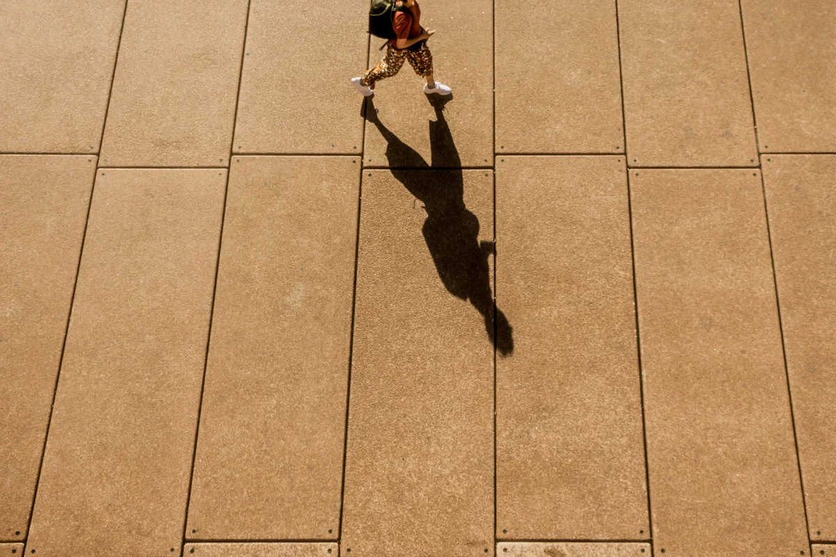 person walking leaving a long shadow