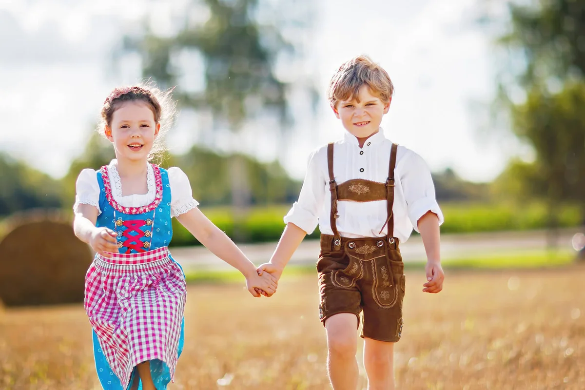 Two kids in traditional Bavarian costumes in wheat field