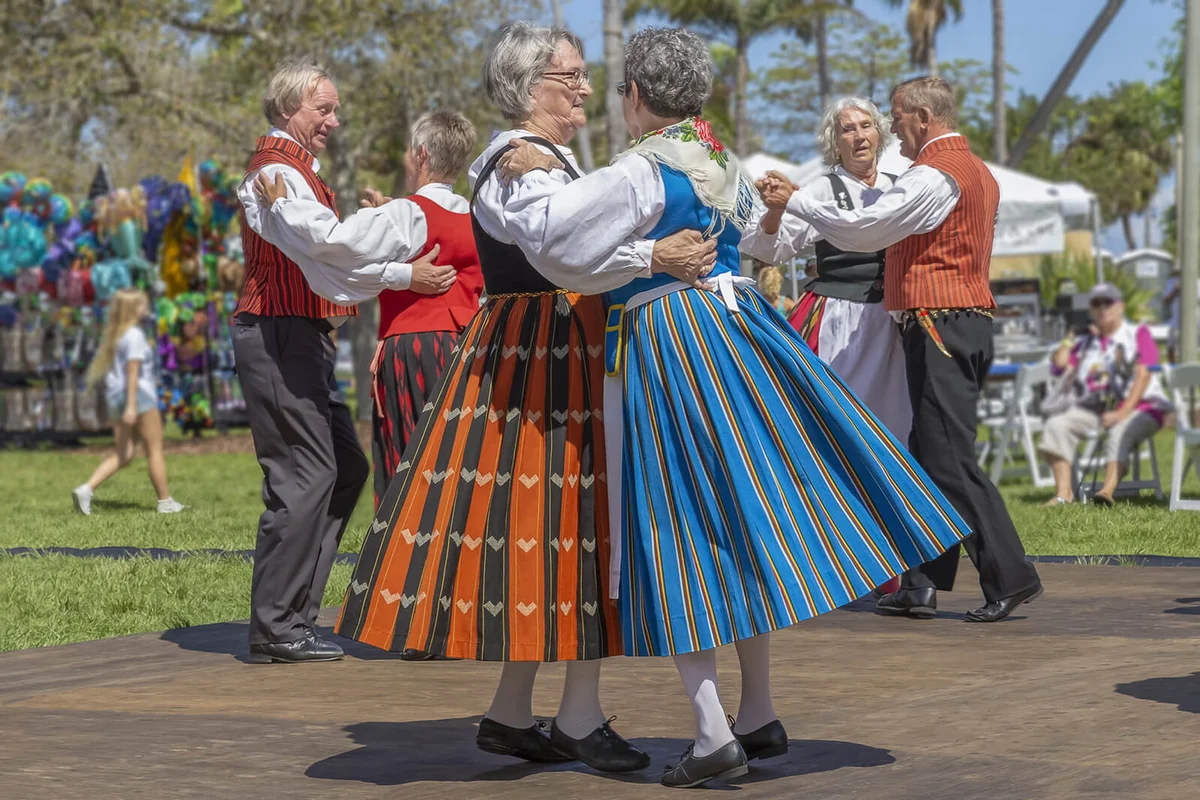 Two women coupled together dressed in period Finnish costume dancing