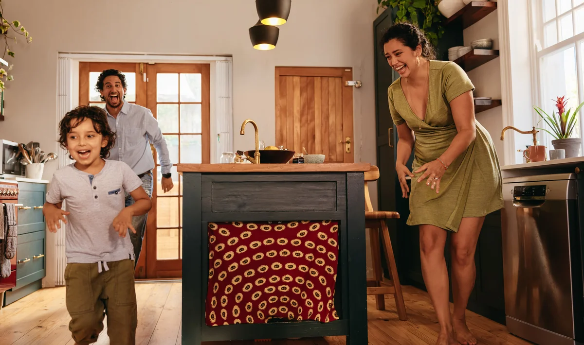 parents racing around with child in kitchen