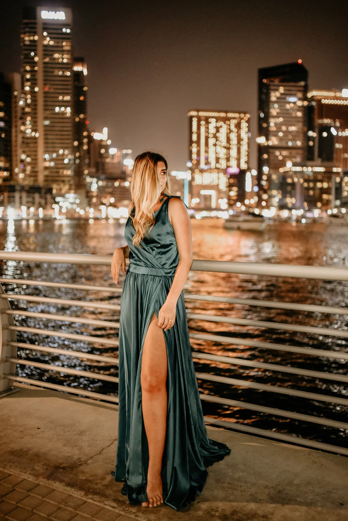 Girl wearing prom dress with city lights in background