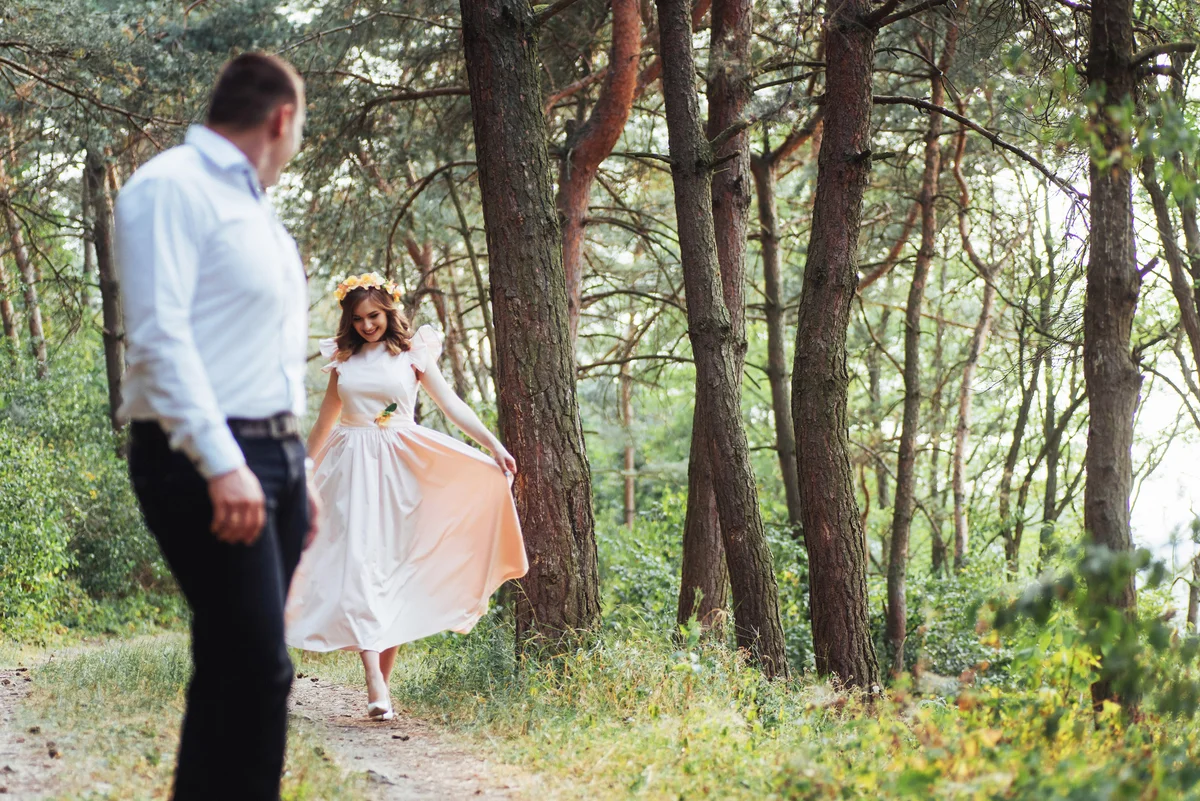 Happy couple dressed up in a pine forest on nature trail