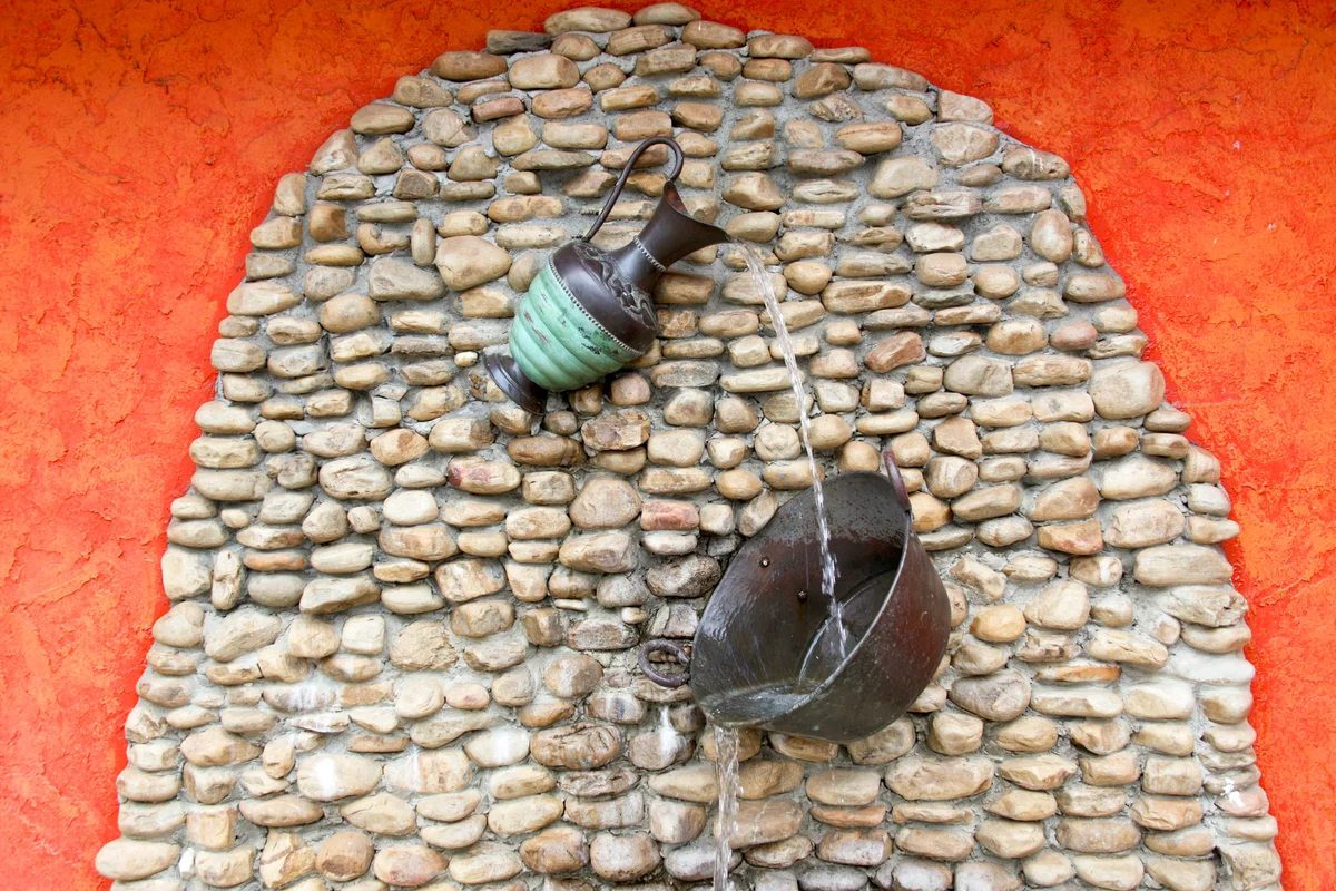 Water Pitcher Fountain on Rock Wall