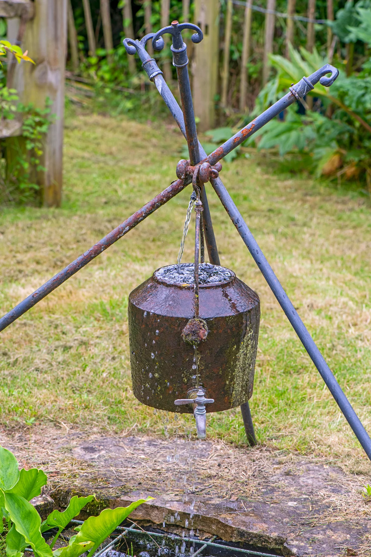 Unusual iron water feature supported by three iron poles