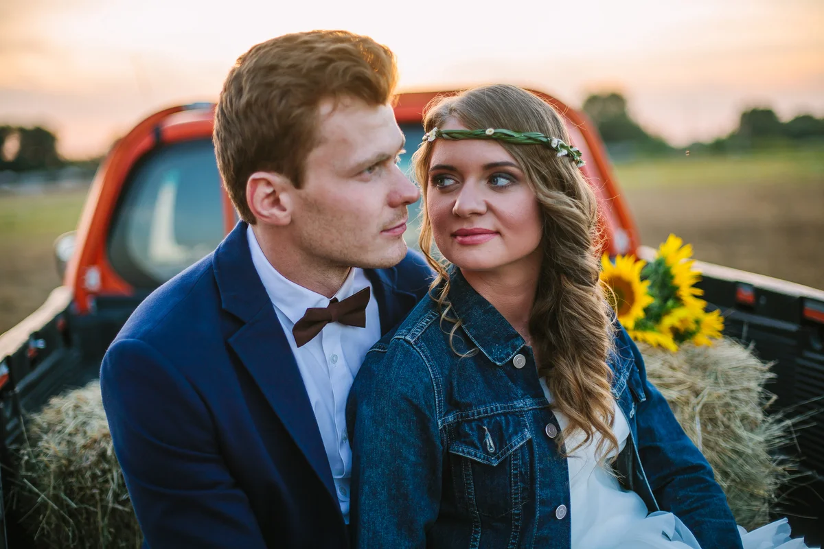 Couple in back of pickup in country setting at sunset