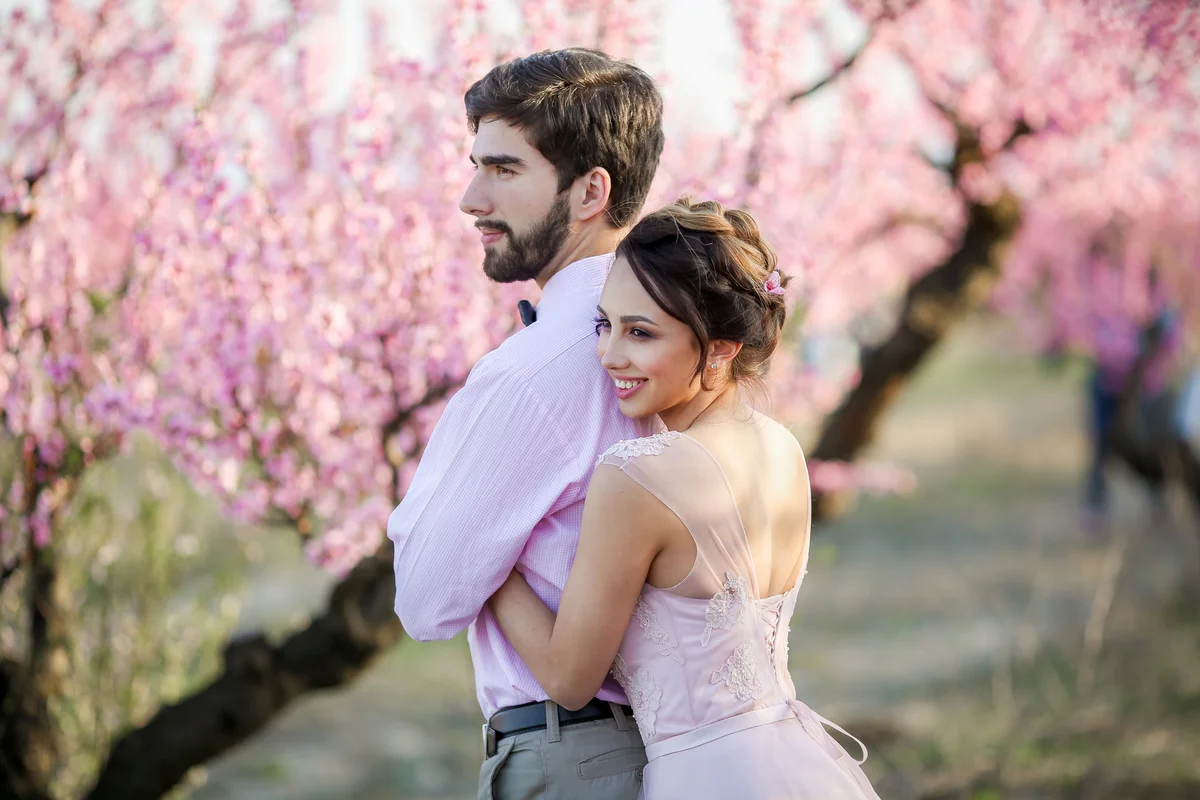 Couple in formal wear posing in apple orchard