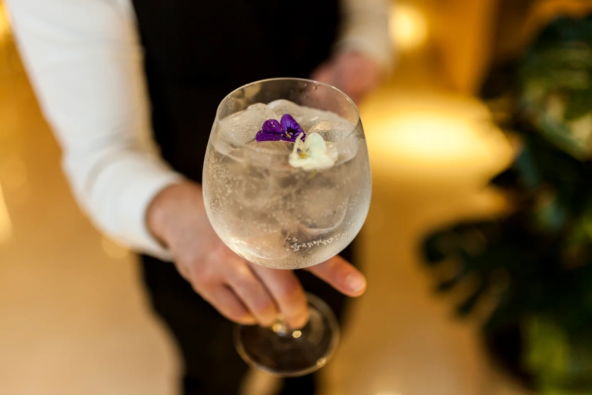 Server serving a gin cocktail