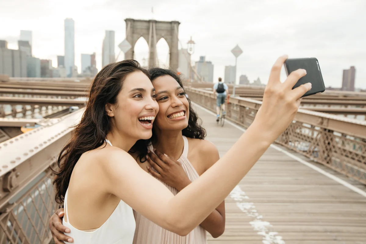 girls taking selfie on Brooklyn Bridge