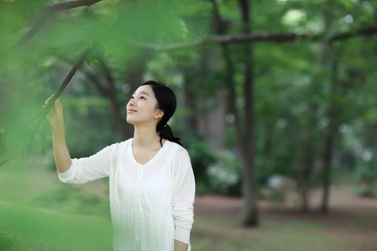 woman in the park touching a tree