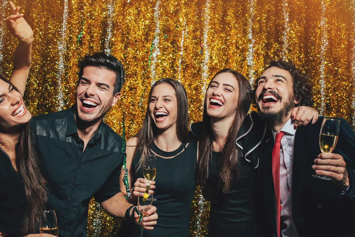 Friends at party with glittery gold backdrop