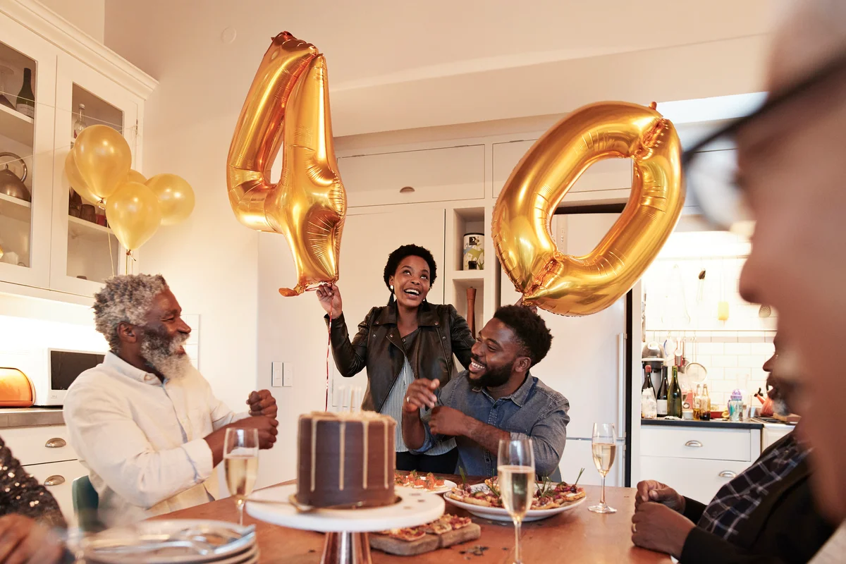 Woman with number 40 balloons at birthday party