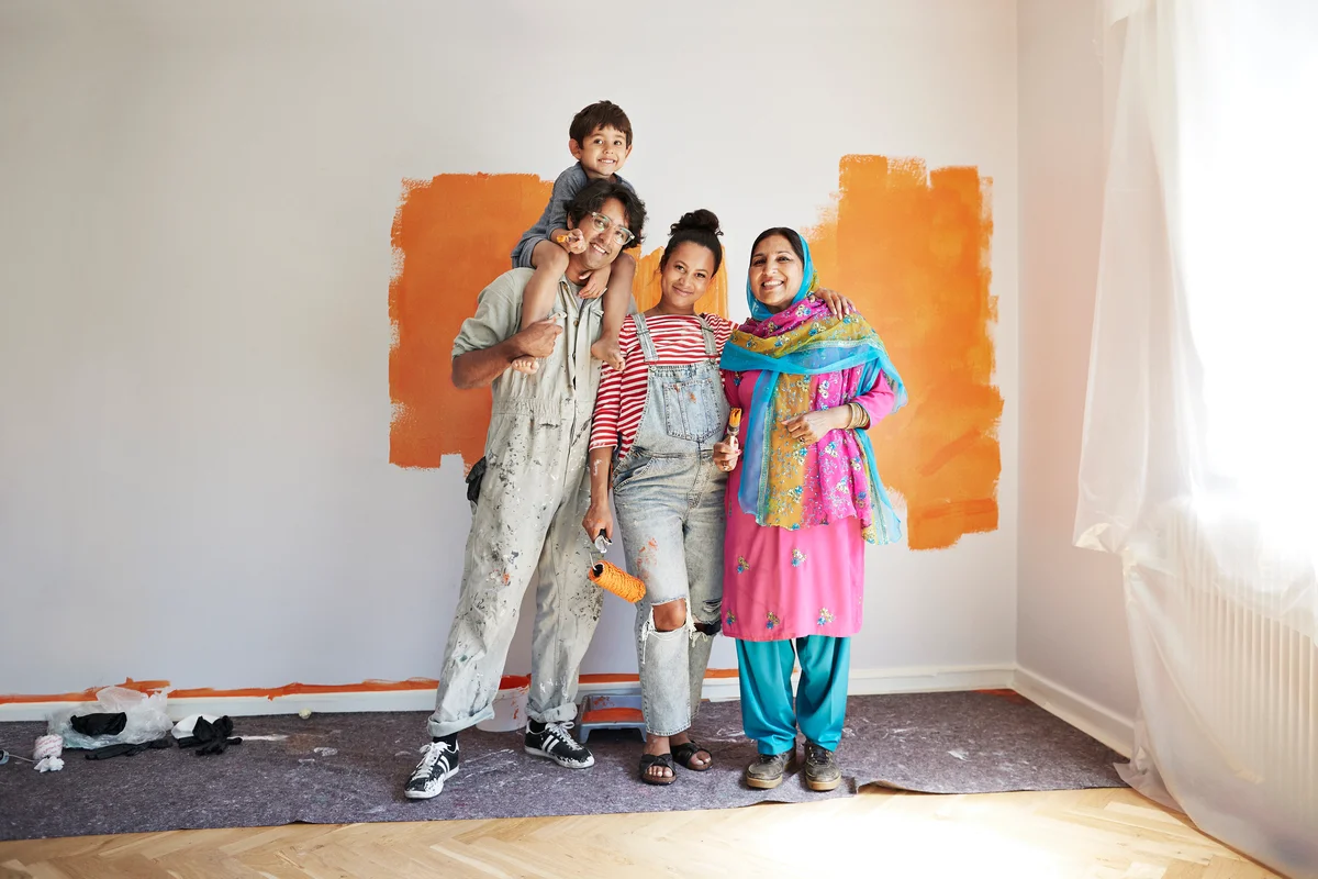 Parents, child and grandma painting room together