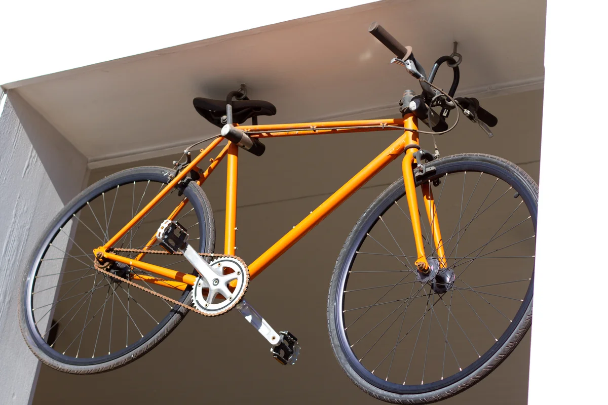 Yellow bike hanging on ceiling hooks