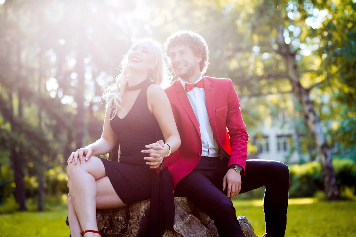 Couple dressed up for prom sitting on rock holding hands