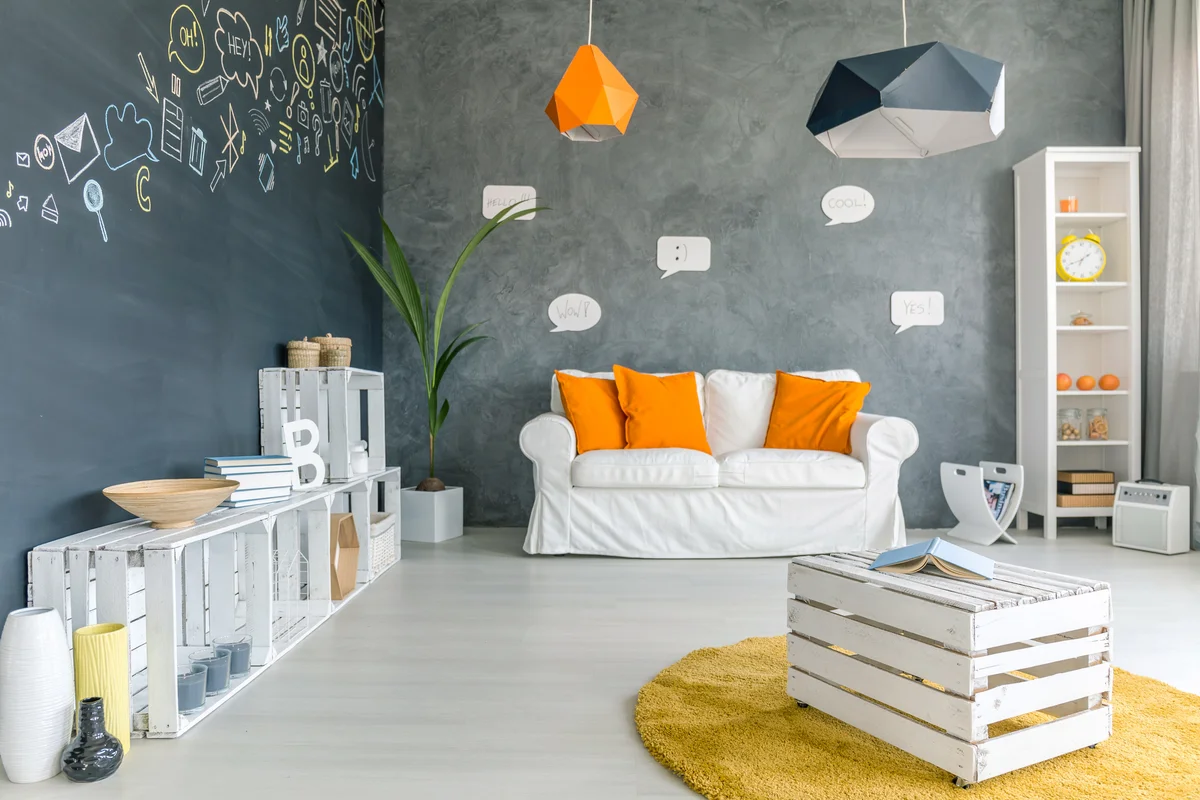 Room with chalkboard wall and wood pallet furniture