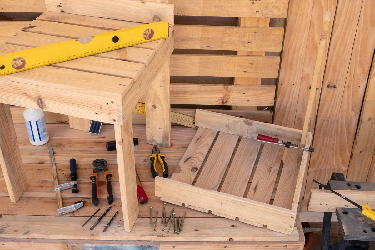 Wooden table with tools to create a new chair made by recycled wood from pallet