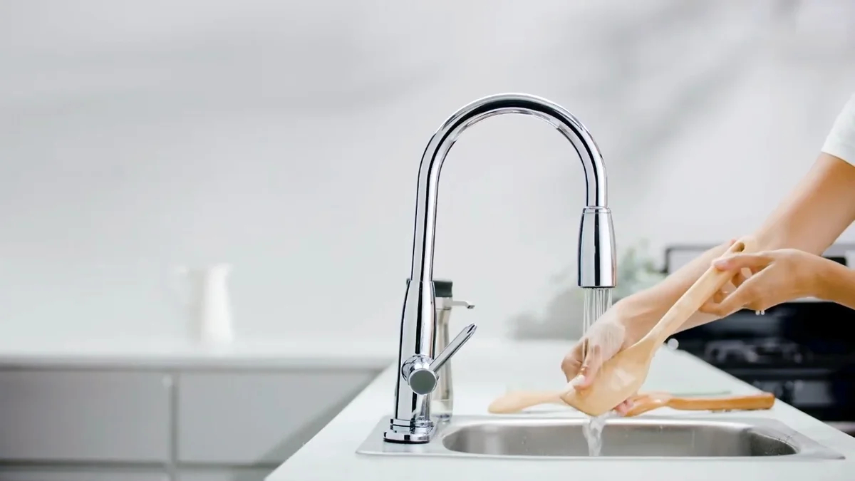 woman washing wooden spoons