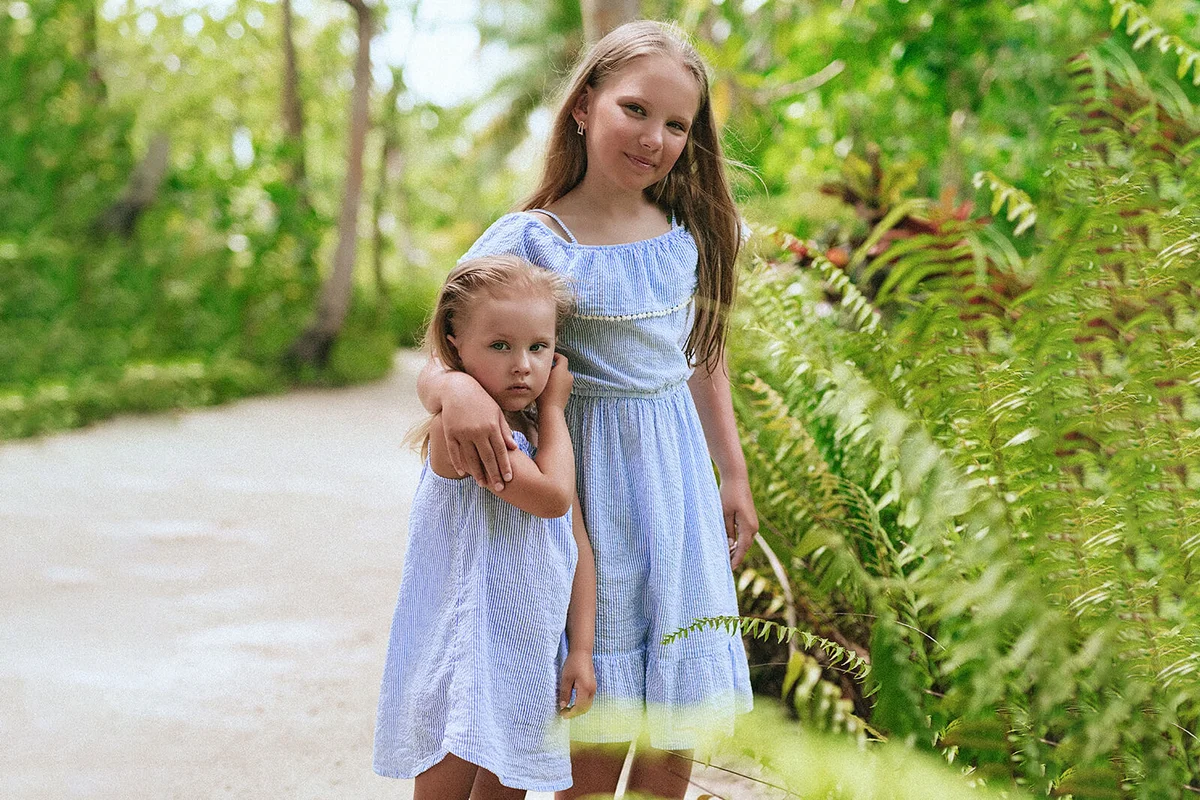 Two little sisters in matching outfits walking together