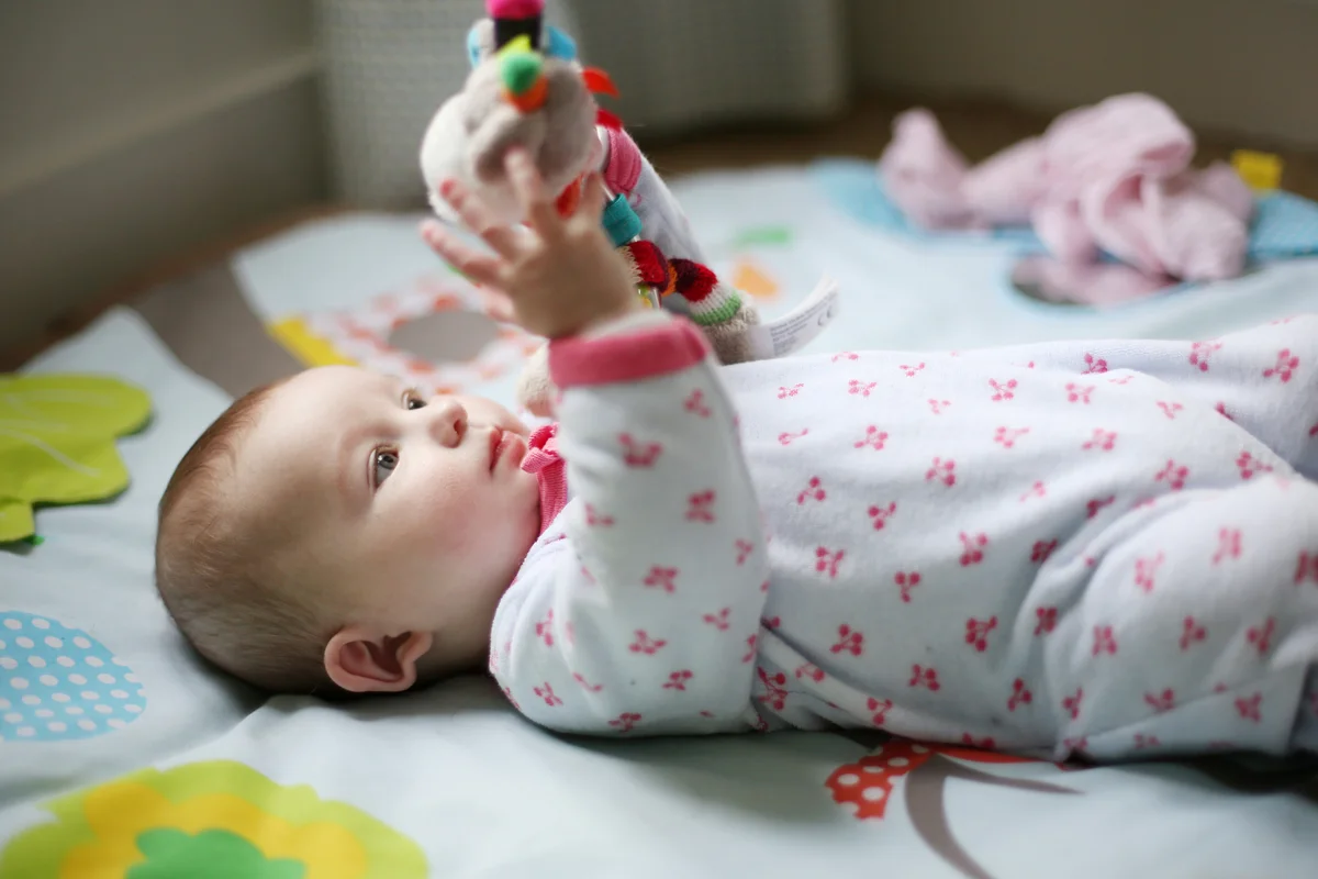 Baby playing with toy with tags