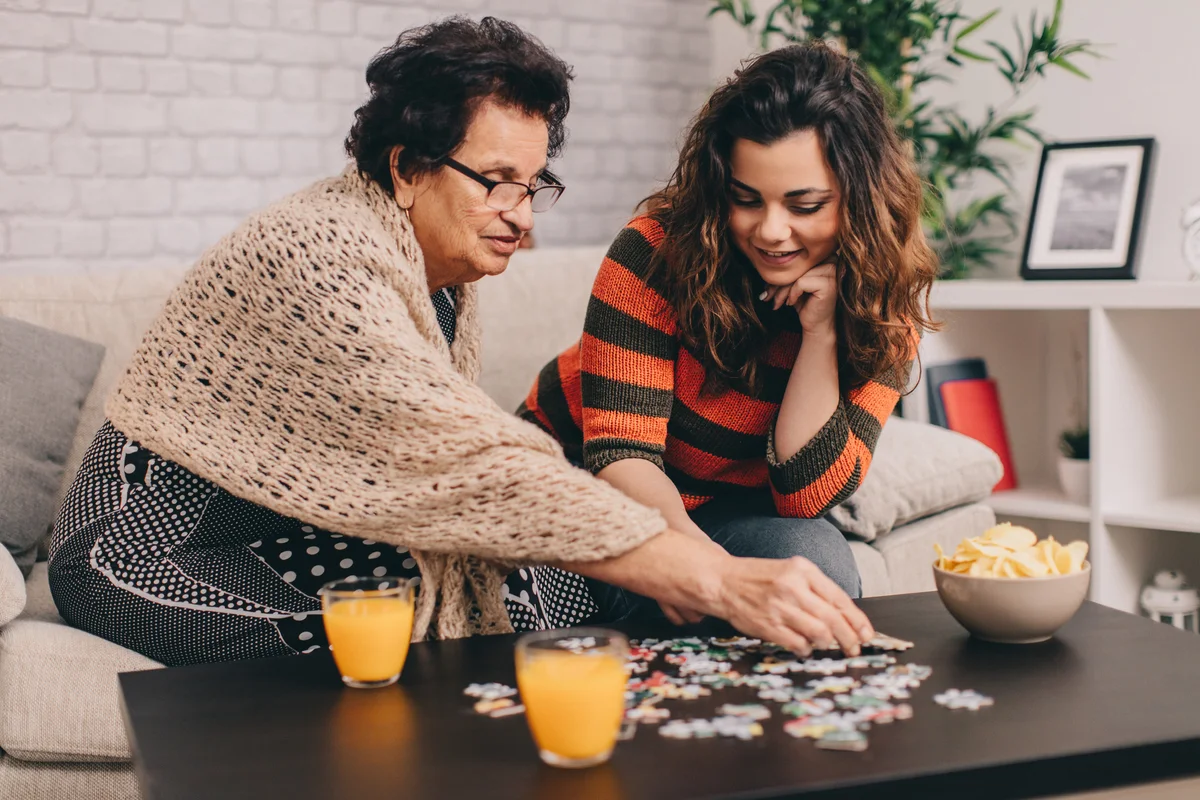 Girl and grandmother doing puzzle