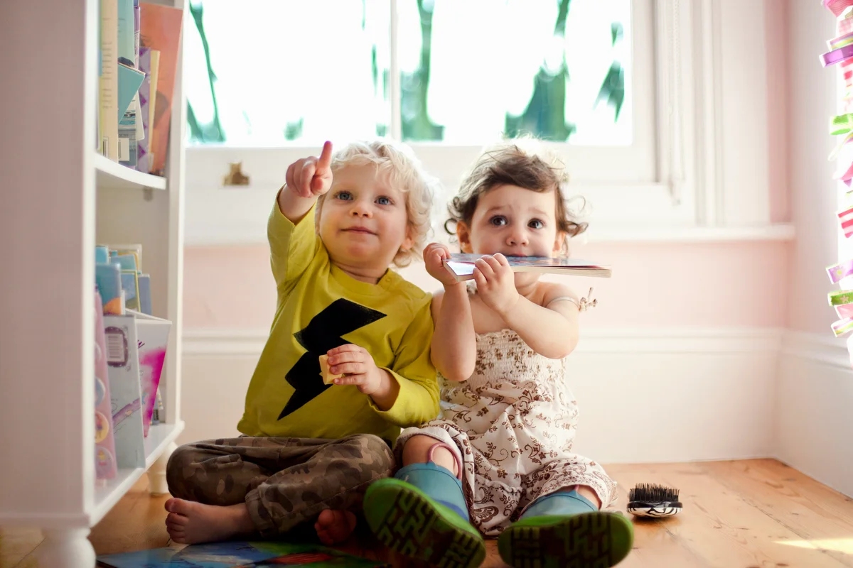 Female and male toddler friends pointing and looking up