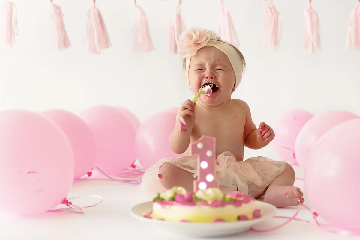 crying baby with smash cake