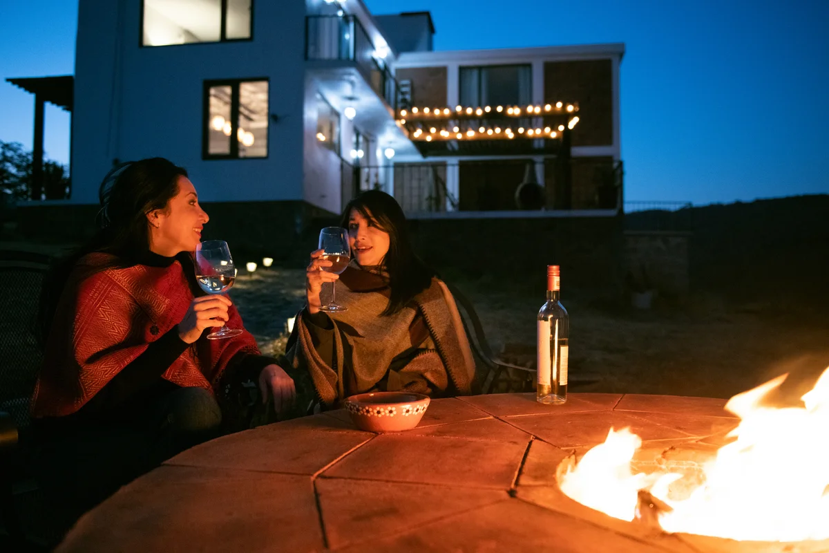 2 women sitting by the outdoor fire pit