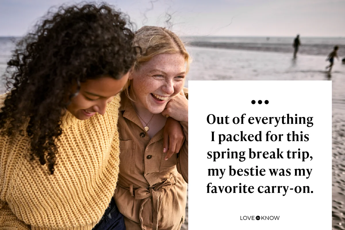 Two happy female friends embracing on the beach