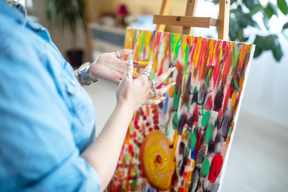 Woman finger painting on canvas