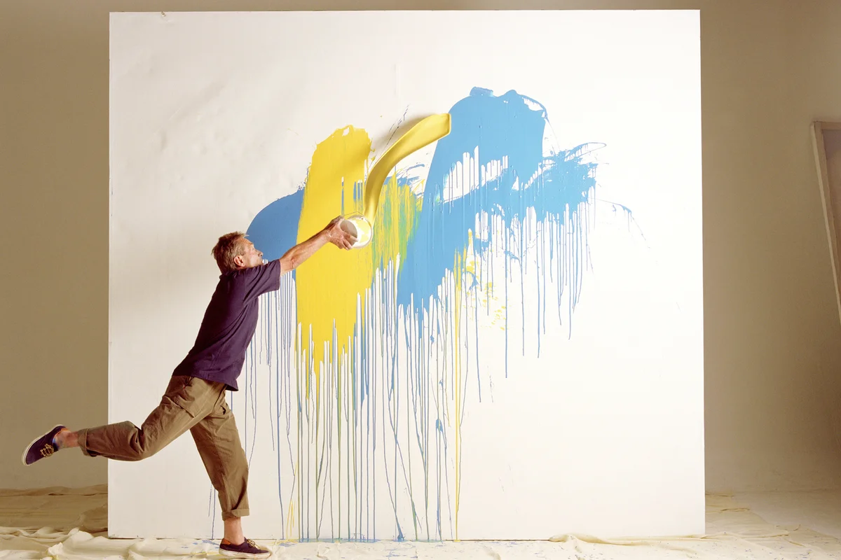 Man throwing paint at canvas