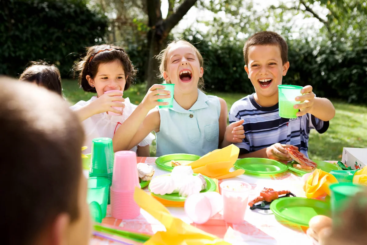 Kids sitting at table, having a garden party